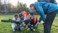 students and teacher work on a drone together