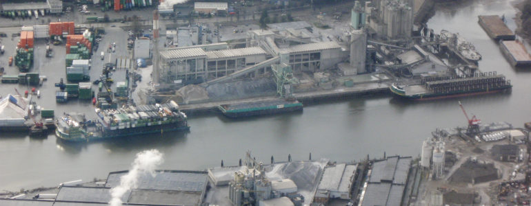 an industrial plant next to an urbanized waterway