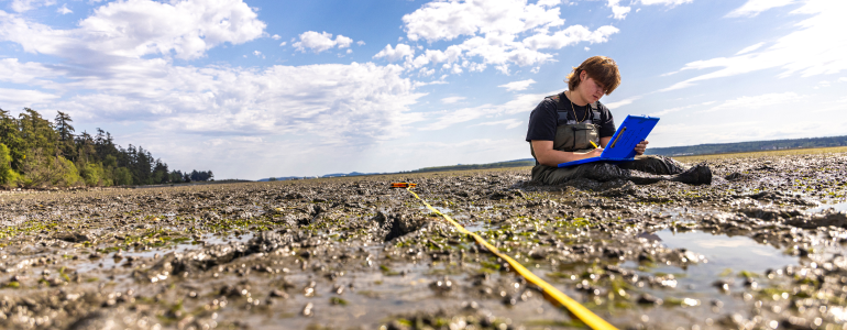 Image of student from the College of the Environment conducting research at Padilla Bay.